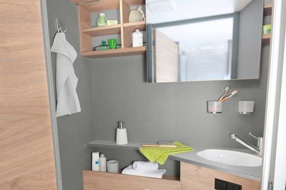 Area toilette luminosa e moderna con specchio scorrevole lateral- mente e molte possibilità di stivaggio e di appoggio • T 7052 DBL